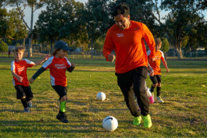 Coach and Children Playing Soccer